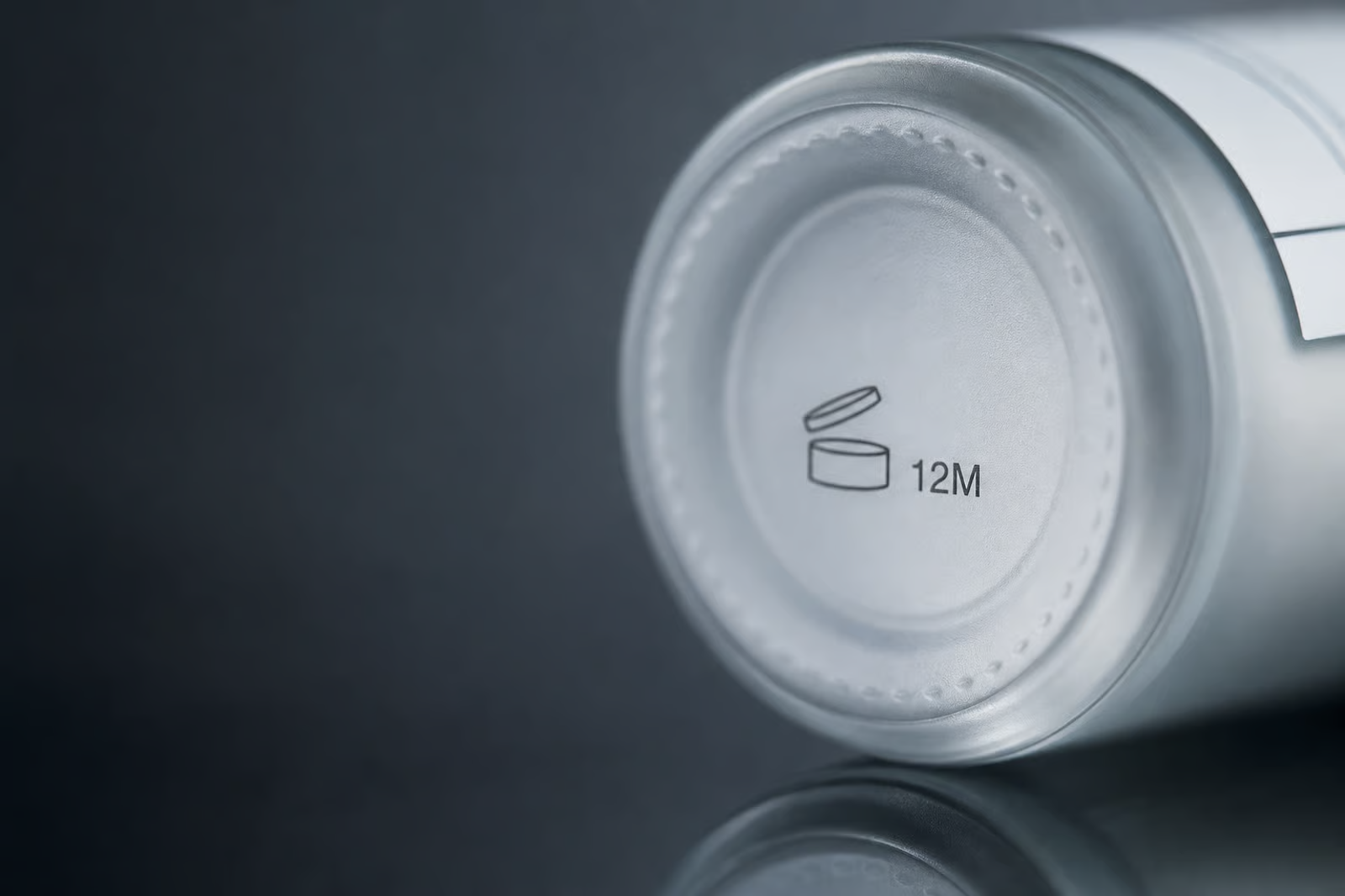 Close-up of the open-jar PAO symbol reading 12M on the base of a bottle